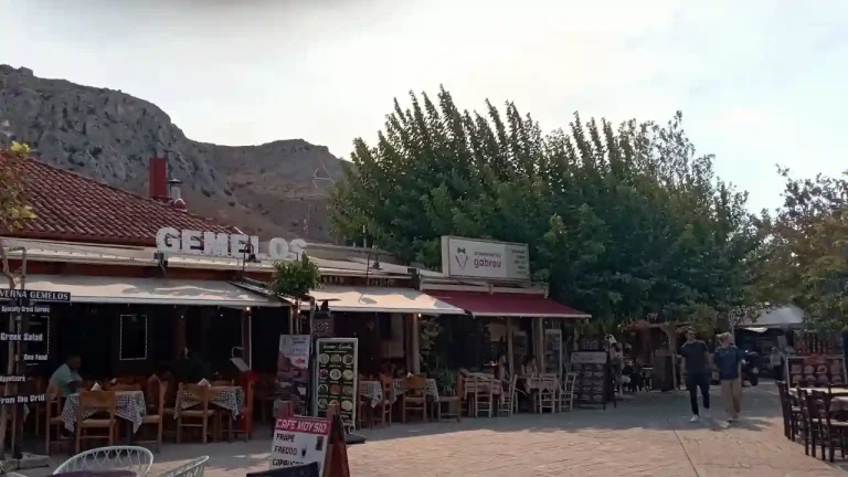 A photo of a cafe - restaurant in Ancient Corinth, Greece. The menu includes items like salad, frappe, and freddo.