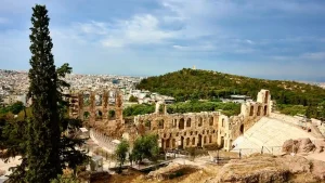 The Odeon of Herodes Atticus, a historic theater on the Acropolis in Athens, Greece. The theater is surrounded by ancient ruins and offers a panoramic view of the city.