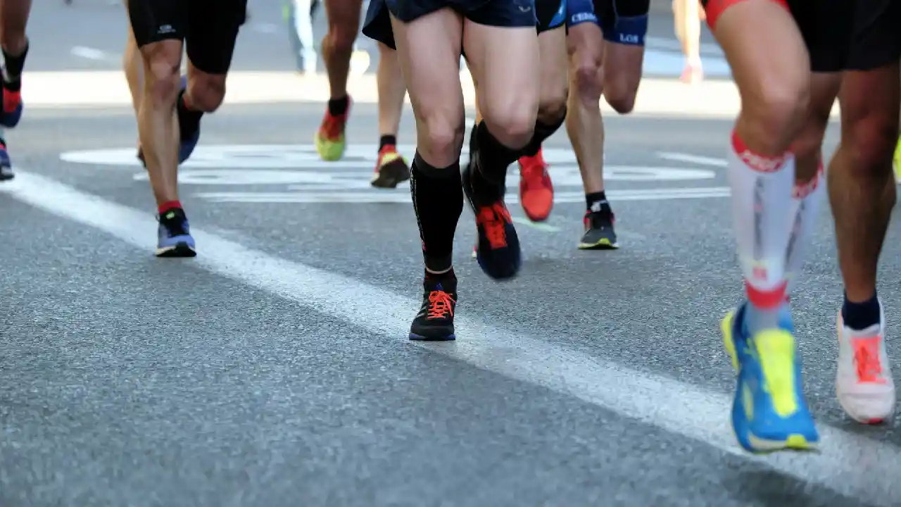 A group of runners in colorful athletic wear running.