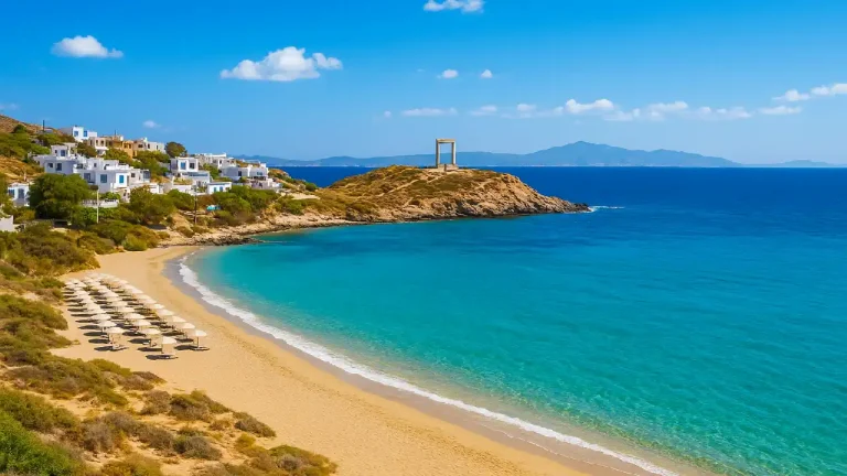 Scenic landscape of Naxos Greece showing turquoise Aegean waters, golden sandy beach, white Cycladic houses, and the ancient Portara monument under a bright blue sky.