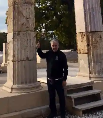 Vasilis, local Athens private driver and tour guide from Athens Cabs, standing at ancient Greek ruins in Greece